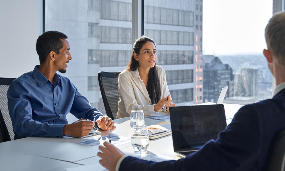 Team Strategy Meeting in Modern Office – Dentist Advisor Group Group of professionals in a corporate meeting discussing dental business strategies and financial planning in a bright modern office – Dentist Advisor Group